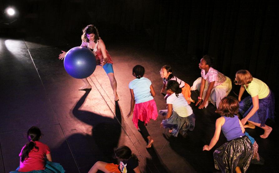Shelley leading group of students in contemporary dance performance embodying the bounce of large ball